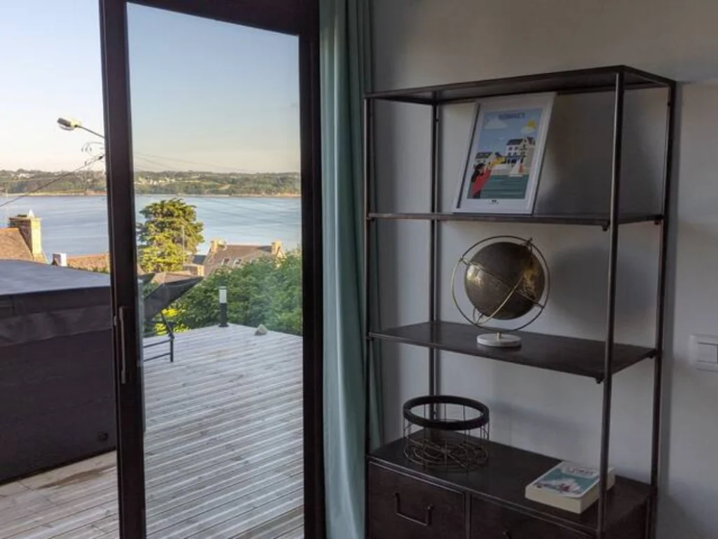 The living room glass doors open onto the deck and the sea